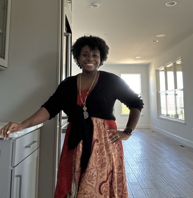 Ivy Sweeney Ross standing in her new home in St. Louis, smiling in a moment of transition and growth.